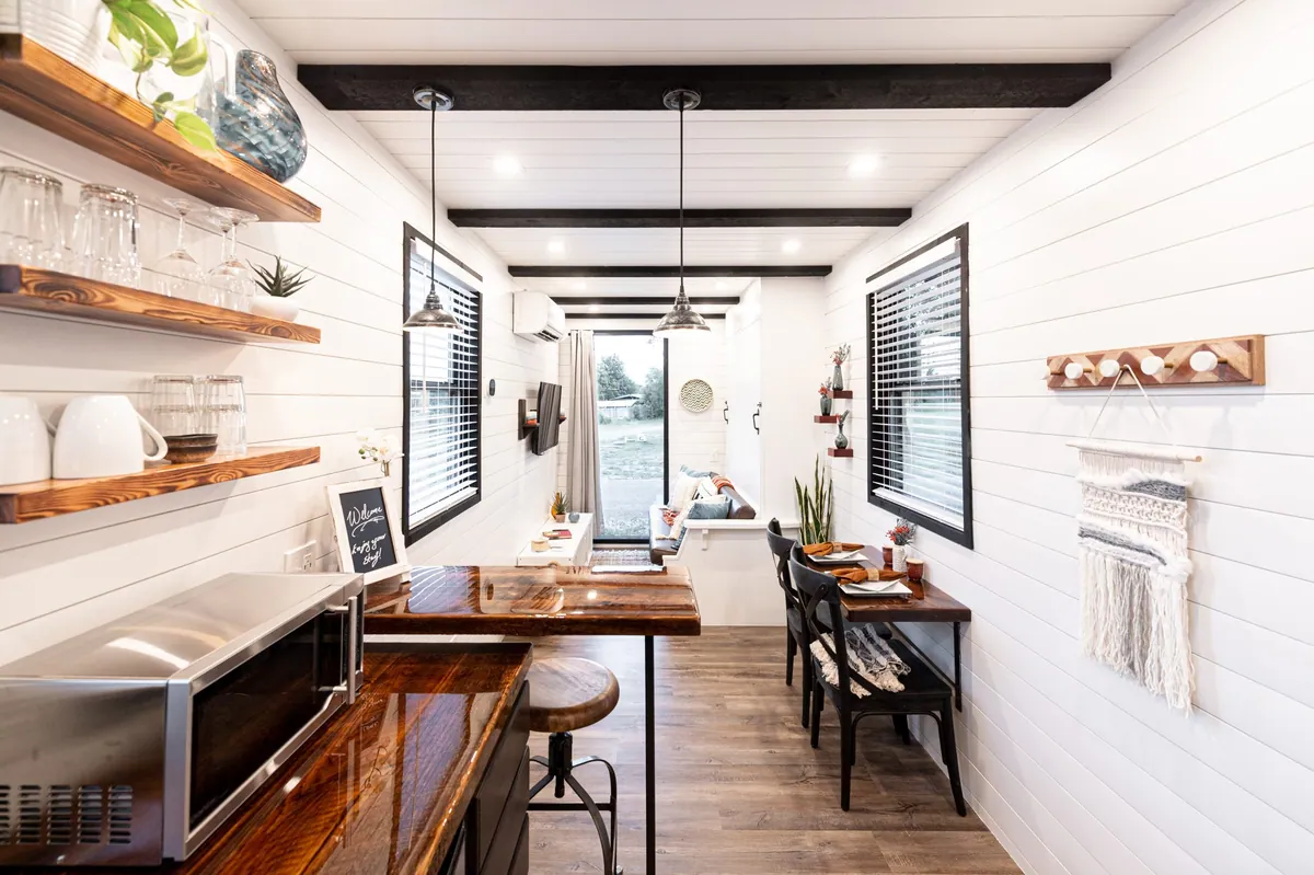 Luxury interior of a prefab tiny house for sale showcasing custom woodwork and modern small-space living design